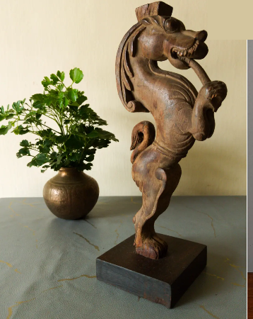 A carved wooden figure beside a brass pot in the Leen's showroom